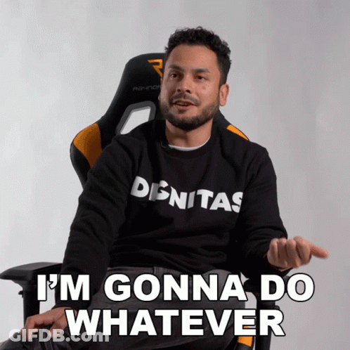 A Man Wearing A Shirt That Says Denitas Is Sitting In A Chair And Says I 'M Gonna Do Whatever GIF