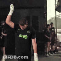 A Man Wearing A Shirt That Says Dhs Is Raising His Hand In The Air GIF
