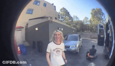 A Man Wearing A Shirt That Says ' Dunkin Donuts ' Stands In A Parking Lot GIF