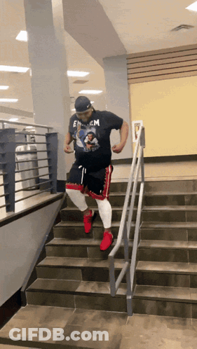 A Man Wearing A Shirt That Says Eminem Is Walking Down Stairs GIF