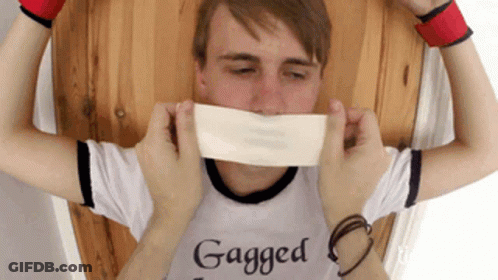 A Man Wearing A Shirt That Says " Gagged " Is Being Tickled GIF