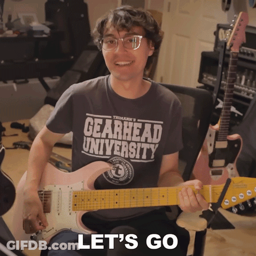 Man Wearing Gearhead University Shirt Holding Guitar GIF