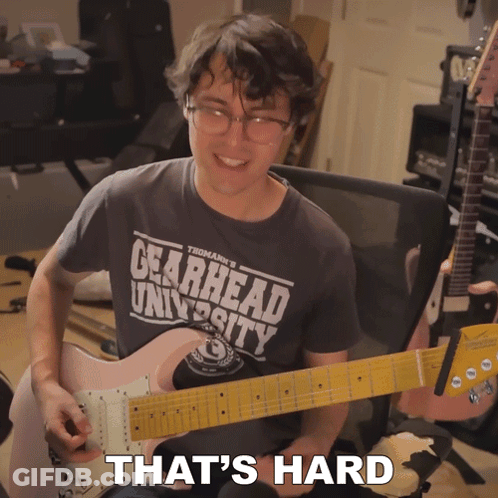 A Man Wearing A Shirt That Says Gearhead University Playing A Guitar GIF