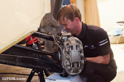 A Man Wearing A Shirt That Says Gmc On It Is Working On A Car GIF