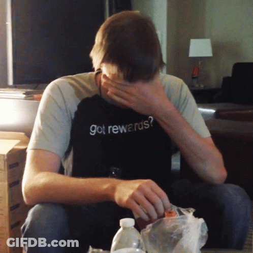 A Man Wearing A Shirt That Says Got Rewards Covers His Face GIF