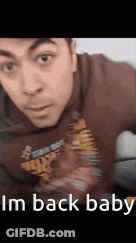 A Man Wearing A Shirt That Says I 'M Back Baby Looks At The Camera GIF