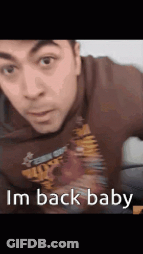 A Man Wearing A Shirt That Says ' I 'M Back Baby ' GIF