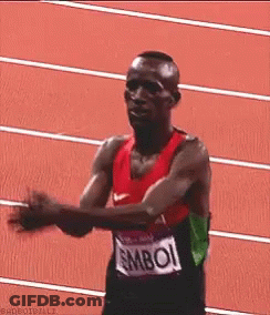 A Man Wearing A Shirt That Says ' Mboi ' On It Is Running On A Track GIF