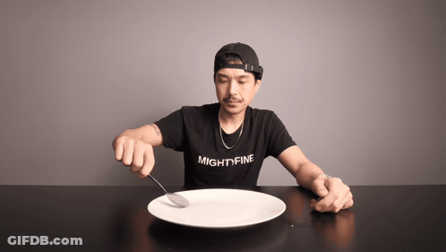 A Man Wearing A Shirt That Says Mightyfine Is Holding A Spoon Over A Plate GIF