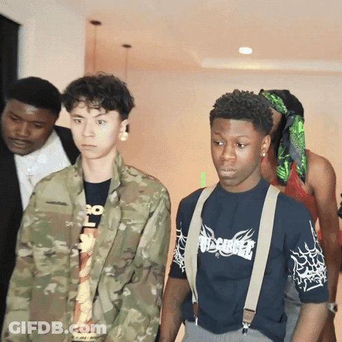 A Man Wearing A Shirt That Says Misfits Is Standing Next To A Man In A Camouflage Jacket GIF