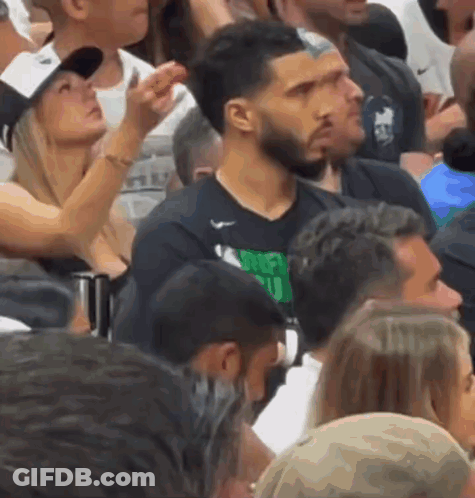 A Man Wearing A Shirt That Says Money Club Is Surrounded By Other People GIF