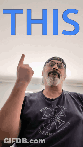 A Man Wearing A Shirt That Says Motion Picture Editor Holds His Finger Up GIF