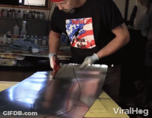 A Man Wearing A Shirt That Says ' Punk ' On It Is Working On A Piece Of Metal GIF