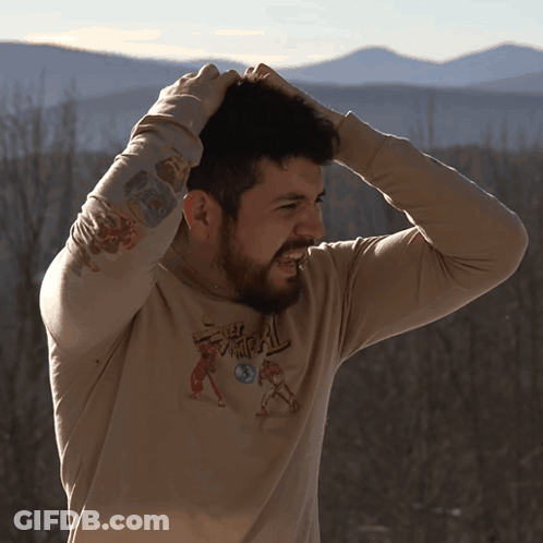 A Man Wearing A Shirt That Says Samurai Holds His Head GIF