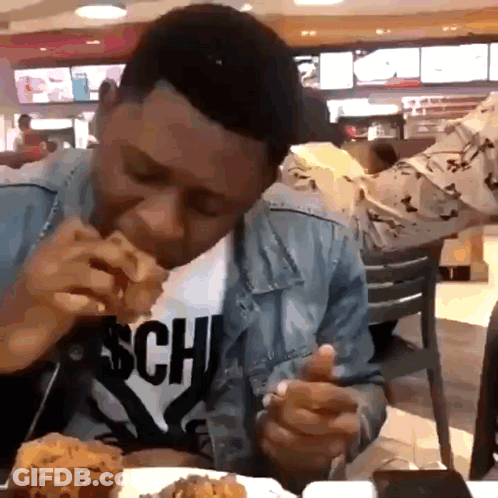 A Man Wearing A Shirt That Says Sch On It Is Eating Fried Chicken GIF