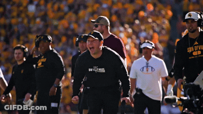 A Man Wearing A Shirt That Says Son Of Evil Stands On A Football Field GIF