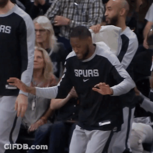 A Man Wearing A Shirt That Says Spurs Is Being Helped By Another Man GIF