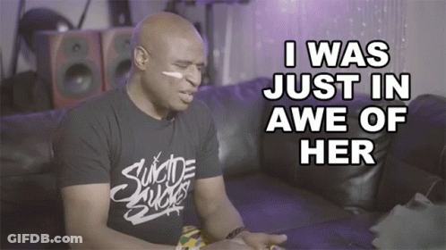 A Man Wearing A Shirt That Says " Suicide Sucks " Sits On A Couch GIF