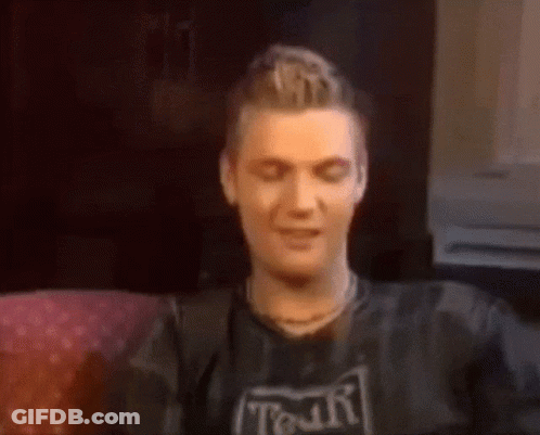 A Man Wearing A Shirt That Says Tour Is Sitting On A Couch GIF