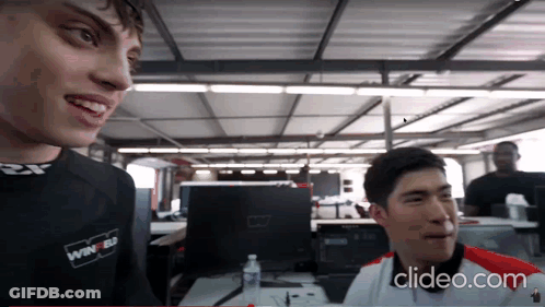 A Man Wearing A Shirt That Says Winner On It Talks To Another Man GIF