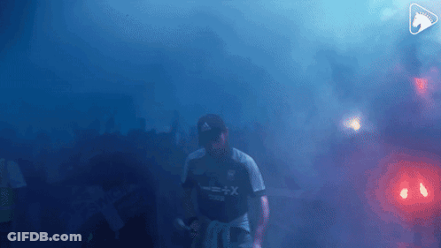 A Man Wearing A Shirt That Says X + X Is Walking Through Smoke GIF