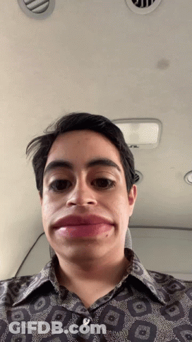A Man Wearing A Shirt With A Geometric Pattern Makes A Funny Face GIF