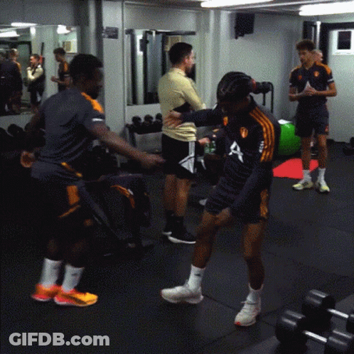 A Man Wearing A Shirt With The Letter A On It Stands In A Gym GIF