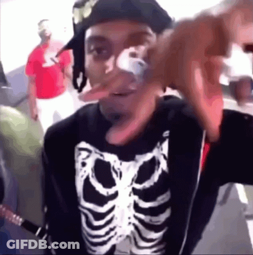 A Man Wearing A Skeleton Shirt And A Hat Is Making A Funny Face GIF