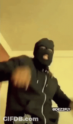 A Man Wearing A Ski Mask And Holding A Gun Is Dancing . GIF