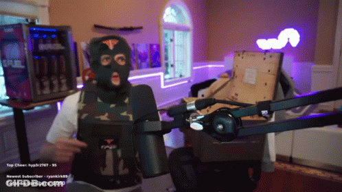 A Man Wearing A Ski Mask Stands In Front Of A Microphone With The Number 1090 In The Corner GIF