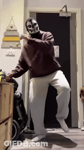 A Man Wearing A Skull Mask Is Dancing In A Room GIF