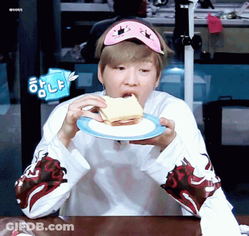 A Man Wearing A Sleep Mask Is Eating A Piece Of Sandwich GIF