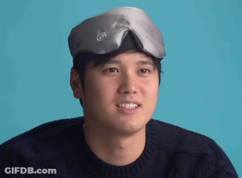 A Man Wearing A Sleep Mask On His Head Smiles GIF