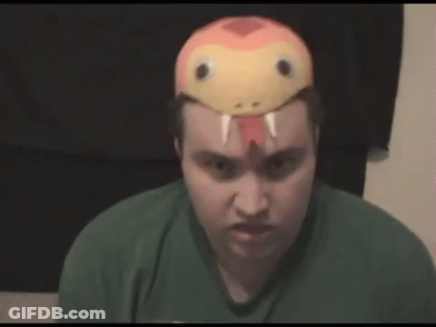 A Man Wearing A Snake Mask On His Head Is Making A Funny Face . GIF