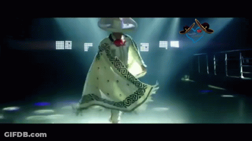 A Man Wearing A Sombrero And A White Cape Is Dancing GIF