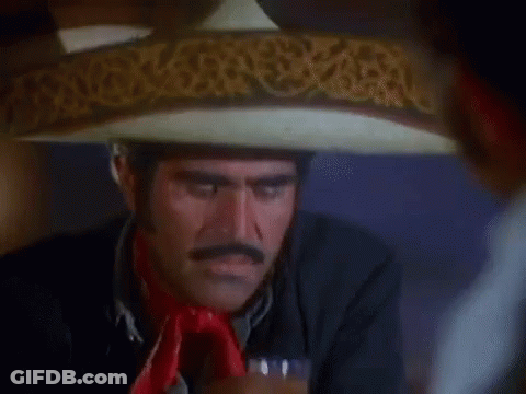 A Man Wearing A Sombrero Is Drinking A Glass Of Beer . GIF