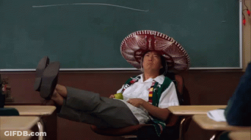 A Man Wearing A Sombrero Sits In A Chair In Front Of A Chalkboard GIF