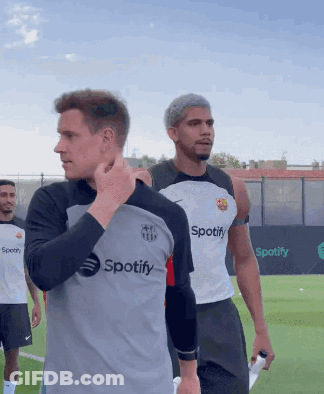 A Man Wearing A Spotify Shirt Stands On A Field GIF