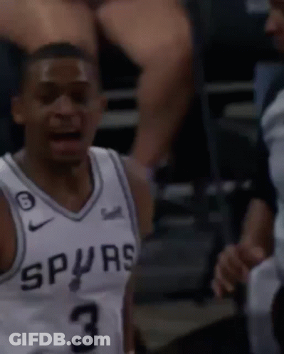 A Man Wearing A Spurs Jersey Is Talking To A Referee GIF