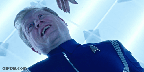 A Man Wearing A Star Trek Uniform Is Smiling And Looking Up GIF