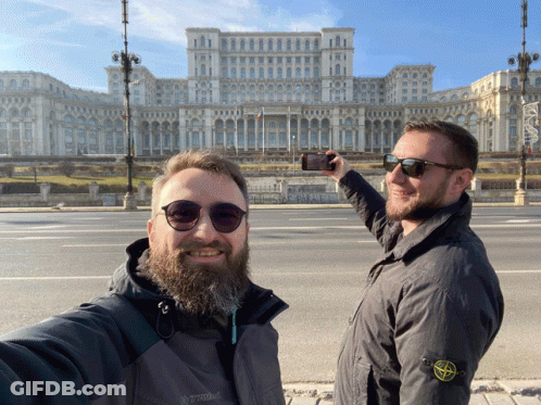 A Man Wearing A Stone Island Jacket Takes A Selfie With Another Man GIF