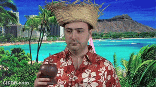 A Man Wearing A Straw Hat And A Hawaiian Shirt Is Holding A Bottle In Front Of A Beach GIF