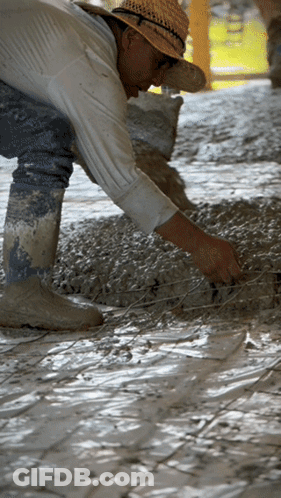 A Man Wearing A Straw Hat Is Working On A Tile Floor GIF
