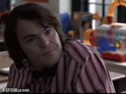 A Man Wearing A Striped Shirt And A Bow Tie Is Sitting At A Table . GIF