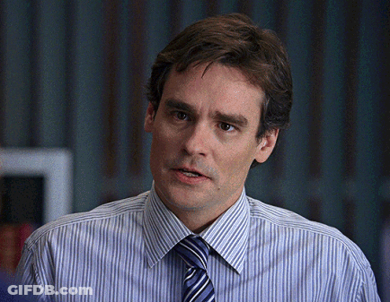 A Man Wearing A Striped Shirt And Tie Looks To The Side GIF