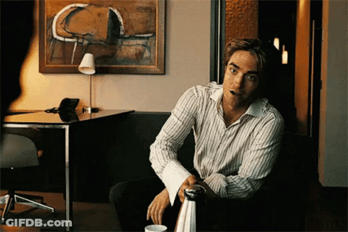 A Man Wearing A Striped Shirt Is Sitting On A Couch GIF