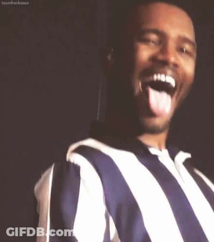 A Man Wearing A Striped Shirt Is Sticking His Tongue Out . GIF