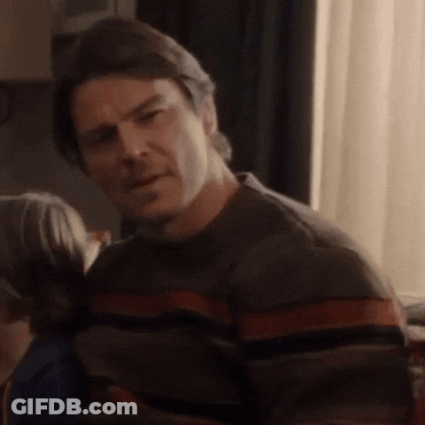 A Man Wearing A Striped Sweater Is Looking At Something GIF