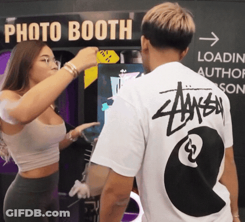 A Man Wearing A Stussy Shirt Stands Next To A Woman GIF