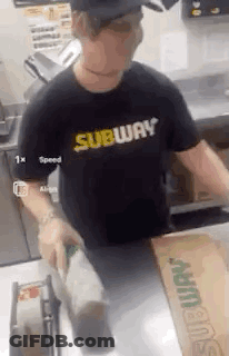 A Man Wearing A Subway Shirt Is Standing In A Kitchen . GIF